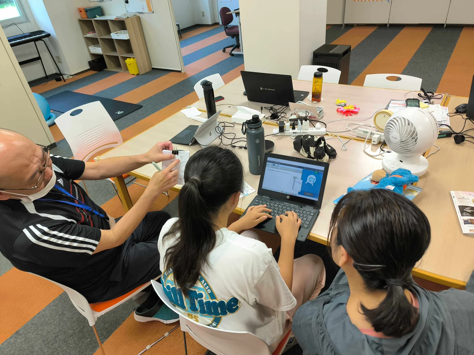 帯広東教室 PC学習支援 — スタッフが手元でヒントを出しながらオンライン教材で学習する様子